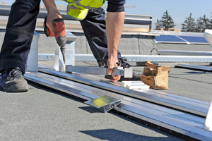  Die Stützen werden mit Schrauben in den Bodenschienen fixiert. Der Abstand von Stütze zu Stütze ist von der Modulbreite abhängig. Dazu wird eine Umrechnungstabelle oder die Lehre verwendet Foto: IBC Solar 