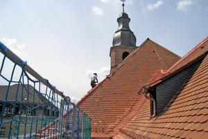  Die Sanierung der Johanneskirche endete nicht unter dem Dach. Insbesondere an Traufe und First, Grat und Kehle wurden Ausbesserungen mit neuen Biberschwanzziegeln vorgenommen. Die Abdeckungen am Gratanfang sind zudem mit barocken Schmuckelementen verziert 