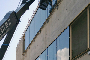  Per Kran werden die Fenster an die Fassade gehoben und befestigt 