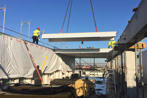  Die Decken werden per Kran eingehoben und an den Betonunterzügen befestigt. Dazu benutzen die Handwerker Klebemörtel 