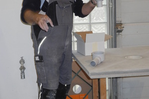  Ein Handwerker zeigt bei den Holzbautagen die Arbeit mit einem Nassraum-Bodenelement von Fermacell 