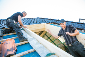  Lutz Wittenbecher (li.) vom Dachdeckerbetrieb George und Daniel Lüdeke (Lideko) öffnen das Dach und bauen die Wechselhölzer sowie den Leimholz-Aufbaurahmen ein Foto: Lideko 