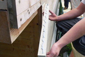  Das Raster aus Kanteln wird an der Fassade mit Silikon ... 