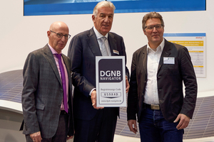  Das Label der Deutschen Gesellschaft für Nachhaltiges Bauen überreichte Johannes Kreißig vom DGNB (Mitte) an Alwitra-Inhaber Joachim Gussner und Josef Löcherbach (links) von der Alwitra GmbH. Im Hintergrund die neue Solardachbahn  