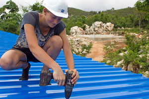 Anja Kubat, Studentin des Bauingenieurwesens, befestigt blaue Wellblechplatten auf dem Auladach 