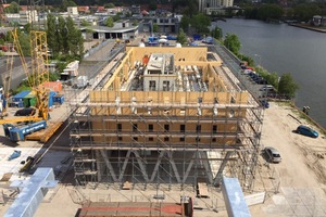  Blick vom Nachbargebäude während der Bauzeit: Gut zu erkennen sind der Kern und der Sockel aus Beton und die umlaufende Holzwandkonstruktion Tom Frantzen Architekten 