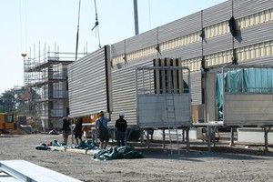  1  Der Kran zieht die Holzrahmenwände mit Lärchenholzverschalung  für die Lagerhallenfassade vom Lkw hoch  Foto Brüninghoff 