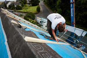  Zur Befestigung schraubten die Handwerker lange Holzbauschrauben schräg durch die Dachlatten und die Dämmung bis in die Sparren hinein 