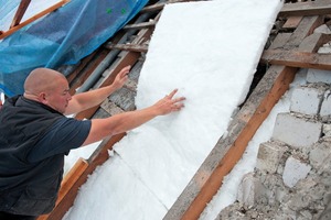  Ein Dämmfilz wird als „Nagelschutz“ in die Sparrenfelder eingebracht
 