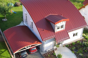  Die Profile werden auch auf Einfamilienhäuser eingesetzt. Das Bogendach mit angrenzendem Carport hat einen Radius von rund 17 Meter aus walzgerundeten Profilbahnen  