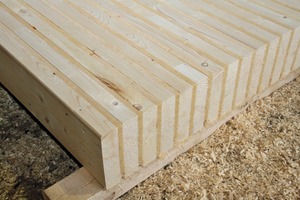  Systemdecke im Sandwichprinzip: hochkant gestelltes Konstruktionsvollholz wird im Wechsel mit Holzfaserdämmplatten gestapelt und maschinell verschraubt 