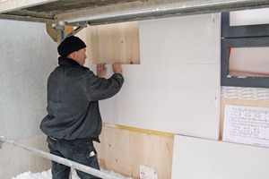  Schmale Außenwand auf Diät: &nbsp;Nach Plan montieren die Handwerker die vorkonfektionierten QASA-Vakuumdämmpaneelen an die Massivholzwand
 