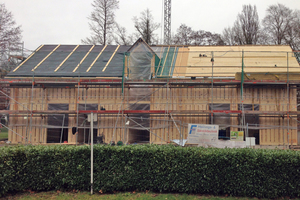  Das Dach ist mit der Behelfsdeckung versehen, die Unterkonstruktion an der Fassade schreitet voran Foto: Oxen Architekten 