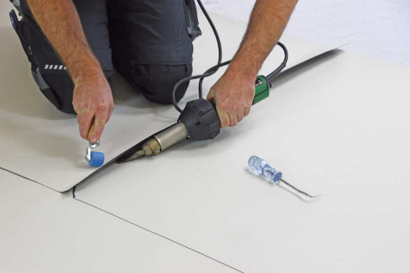 Ausrollen, festkleben und verschweißen - bauhandwerk