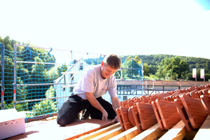  Jürgen Lindemann ist mit dem Decken der Schleppgaube beschäftigt, hier muss die Sturmsicherung angebracht werden 
Foto: Rüdiger Sinn


 