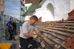  Dachdecker Jürgen Lindemann beim Zusägen einer Bohle für das Anbringen eines Dachhakens  Foto: Rüdiger Sinn 