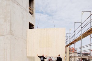  Um das Treppenhaus aus Beton herum stellen die Zimmerer die Brettsperrholzwände auf 