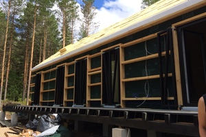  Hier sind die Querbalken an der Fassade zu sehen. Sie halten die tragenden Holzrahmen zusammen 