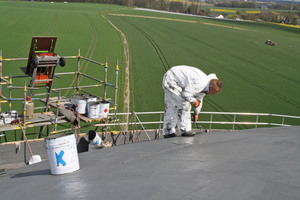  Ein Dachdecker trägt Flüssigkunststoff am stark geneigten Kuppeldach auf<br /> 