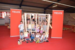  Kinder des Fröbelhauses Sonneborn mit dem Pavillon, den die Zimmerer der Nationalmannschaft bei Velux gebaut haben 