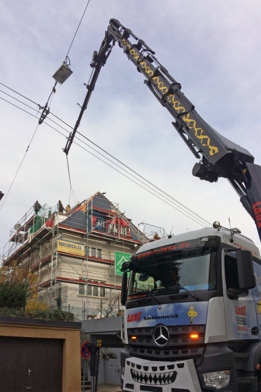 Knifflige Aufgabe: Per Kran wurde das Balkonausstiegsfenster über die Oberleitungen zum Dach transportiert  Foto: Lideko