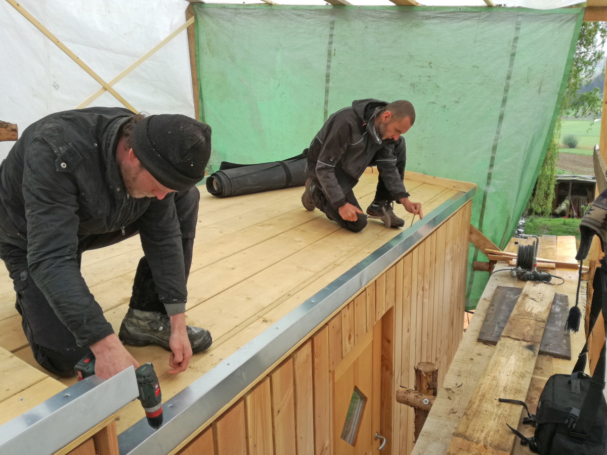 Letzte Vorbereitung der Dachfläche: Die Dachrinnen werden von Oliver Karolius (links) und Holger Längle bündig an die Dachkante geschraubt  Foto: Rüdiger Sinn