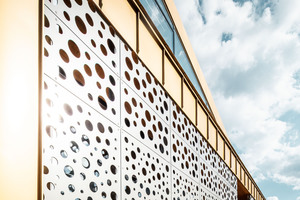  Die Markthalle im ungarischen Nagykörös strahlt mit der Aluminium-Stehfalzfassade aus Mayagold und den gelochten Aluminiumverbundplatten in der Sonne 