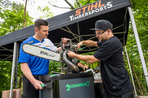  Timbersports-Teilnehmer Thomas Hofbauer (links) prüft seine "Hot Saw" Wettkampfsäge mit Unterstützung eines Technikers 