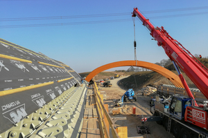  Die Wildbrücke besteht aus zwei bogenförmigen Tragwerken. Unter der breiteren Hälfte der Brücke verläuft die B101 auf vier Spuren  