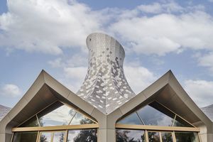  Der 26 m hohe Turm aus einer geschwungenen Holztragkonstruktion ist der Blickfang des Gebäudes


 