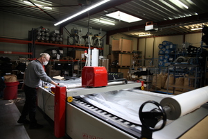  An einer Cutter-Maschine werden bei FHB die schweren Cord-Stoffe zugeschnitten 