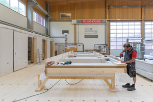  Endmontage der Wandelemente im Werk von Holzbau Bruno Kaiser: Hier werden die Fenster und die vorvergraute Holzfassade aus Weißtannenholz montiert  