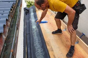  Die Plane wird zurückgeschlagen. Sowohl die Holzschalung als auch die EPDM-Bahn sprüht Rolf Laicher mit Kontaktkleber ein 