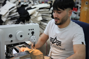  Ein Mitarbeiter von FHB in Spenge bei der Arbeit an der Nähmaschine 