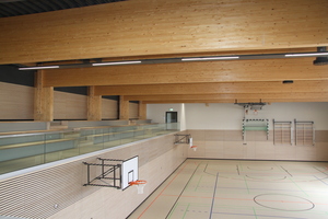  Blick in die Sporthalle des Bildungsdorfs an der Klingenbergstraße: Brettschichtholzbinder tragen das Dach der Turnhalle 