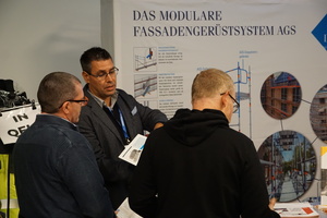  Besucher des Fachkongresses für Absturzsicherheit in Gelsenkirchen informieren sich am Stand von Layher über Gerüstsysteme 