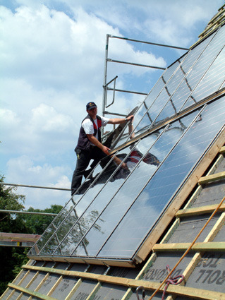 Dachdecker installiert Phototoltaikmodul auf Steildach