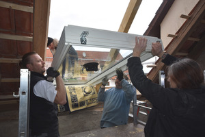  Einbau des Fakro-Dachfensters im Team. Eine Decke schützt den Wechsel in der Dachöffnung vor Beschädigungen beim Einbau 