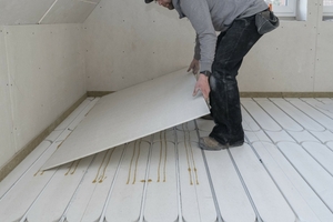  Auf den Fußbodenheizelementen werden Gipsfaserplatten als Decklage verlegt, die verklebt und mit Schrauben fixiert werden 