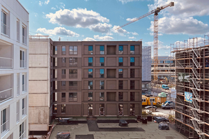  Die Wohnhäuser „K6” und „K7“ während der Bauzeit. An der massiven Hauptkonstruktion wurden vorgefertigte Fassadenelemente in Holzrahmenbauweise montiert 