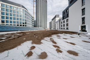  Unter den Grünflächen zwischen den Gebäuden wurden die Drän- und Speicherbahnen „Delta-Floraxx Top“ verlegt. Das Bild zeigt die Bahnen mit Schüttung, die auch zum Beschweren der Vliesüberlappungen dient 