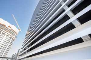  Detailaufnahme der fertiggestellten Fassade einer Technikzentrale auf dem Dach. Hinter der lamellenförmigen Fassadenbekleidung bleibt die „Delta-Fassade 20“ sichtbar 