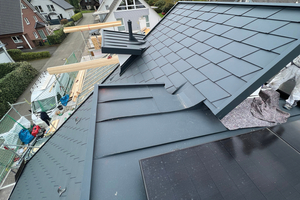  Die steiler geneigten Dachflächen des Hauses wurden mit Aluminiumdachschindeln verkleidet. Die flacher geneigte Pultdachfläche, die zur Rückseite des Gebäudes verläuft, wurde mit Stehfalzblechen verkleidet 