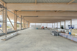  Blick in die Gewerbehalle während der Bauphase: Links ist die Unterkonstruktion für die Montage der Polycarbonat-Paneele an der Fassade zu sehen, rechts sind diese bereits montiert 