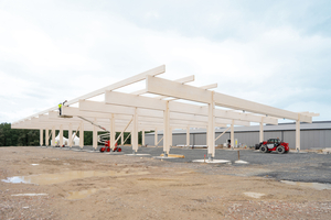  Das Dach der Halle wird von 40 m langen Leimholzbindern getragen, montiert in einem Achsabstand von 6 m. In den Außenbereichen sind die Binder auf Holzstützen gelagert  