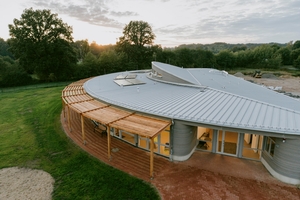  Das Dach des Kindergartens wurde mit Aluminium-Stehfalzprofilen von Kalzip verkleidet. Eine Terrasse mit einer Pergola aus Lärchenholz bietet zusätzlichen Raum zum Spielen und Verweilen im Freien vor dem Kindergarten 