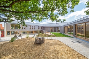  Der Neubau und der aufgestockte Bestand umschließen den begrünten Innenhof von drei Seiten. Die zentrale Eiche markiert den vierten Abschluss 