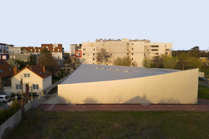  Die Fassade des Sportzentrums wurde mit Aluminiumpaneelen in unterschiedlichen Längen verkleidet, die sich an der Dachwölbung orientieren  