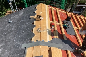  Eine Besonderheit der Dachkonstruktion ist der um rund 2 m in die Dachmitte eingerückte Lüfterfirst. Die dadurch entstandene „Dachhaube“ ist giebelseitig nicht sichtbar  