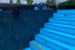  Vor der Abdichtung des Pools wird auf dem Boden, der Treppe und den Wänden ein Schutzvlies verklebt, damit sich kleine Unebenheiten in der Unterkonstruktion später nicht durch die Folie abzeichnen 